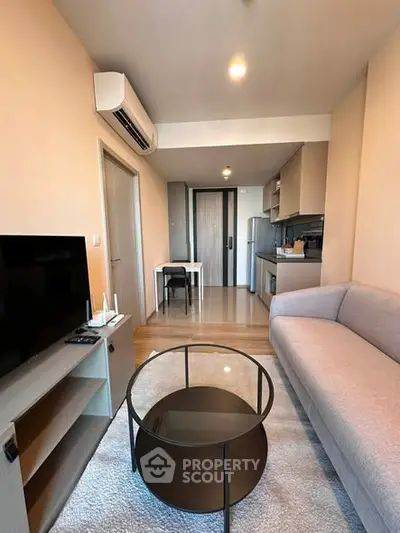 Modern living room with sleek furniture and open kitchen layout in a stylish apartment.