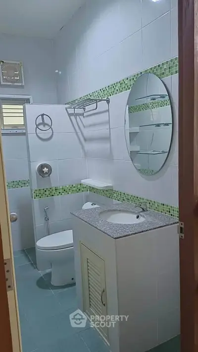 Modern bathroom with stylish green tile accents and sleek fixtures