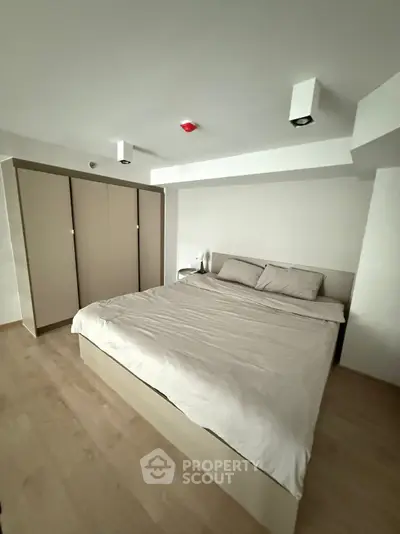 Spacious modern bedroom with minimalist design and ample storage space.