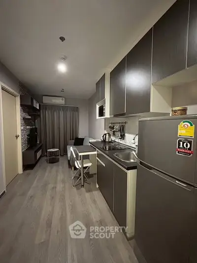 Modern apartment kitchen with sleek cabinets and cozy living area, perfect for urban living.