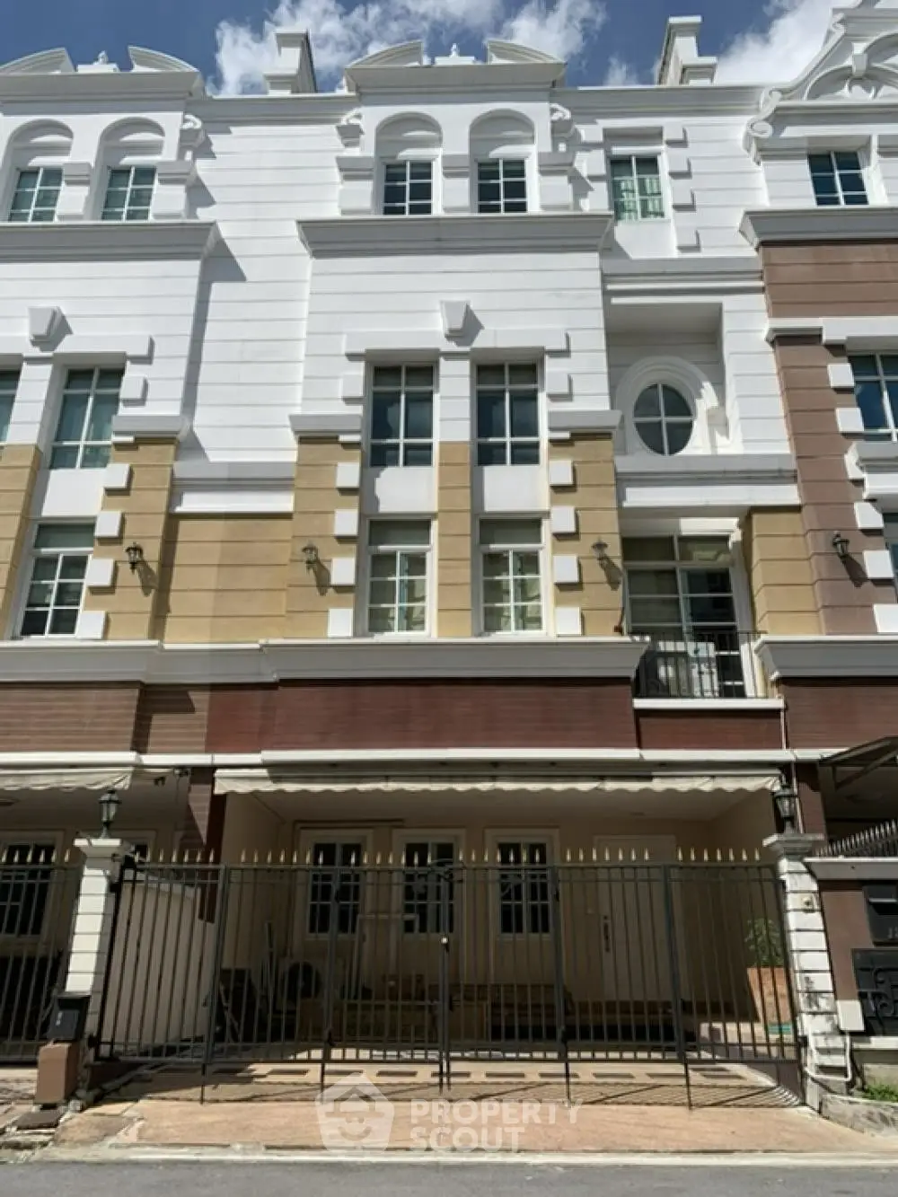 Elegant multi-story townhouse with classic facade and gated entrance