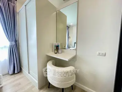 Stylish bedroom with elegant vanity and plush chair, perfect for modern living.