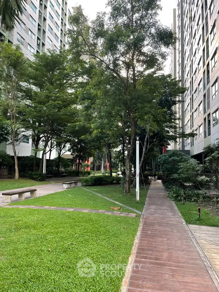 Lush garden pathway in modern residential complex with tall buildings