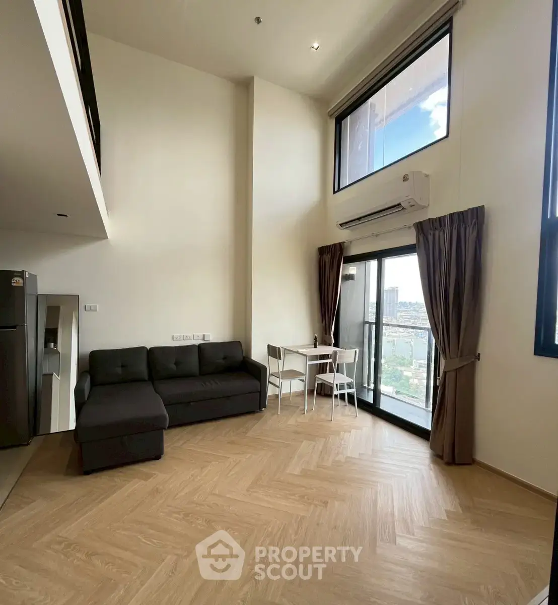 Spacious modern living room with high ceilings and large windows offering stunning city views.