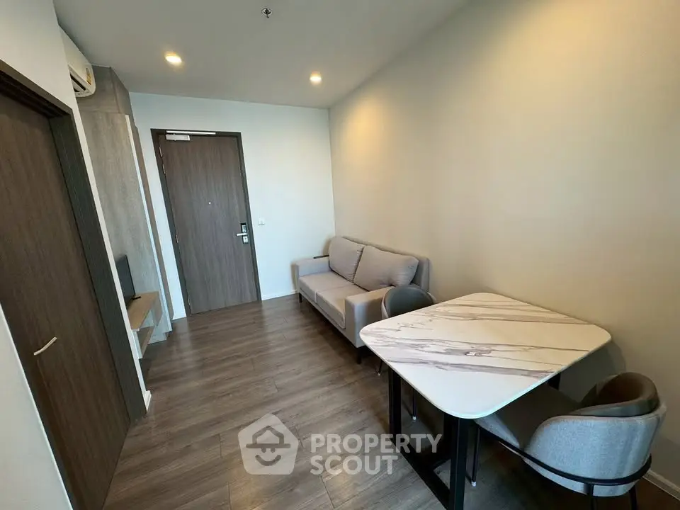 Modern living room with sleek furniture and wooden flooring in a cozy apartment.