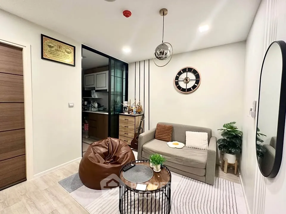 Cozy living room with modern decor and compact kitchen in open layout apartment.