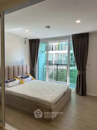 Modern bedroom with large windows and balcony view in a stylish apartment.
