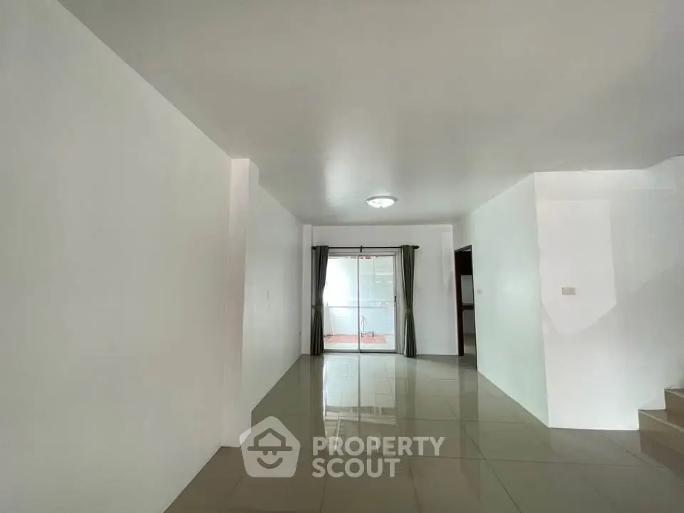 Spacious open-plan living area with glossy tiled floors and natural light