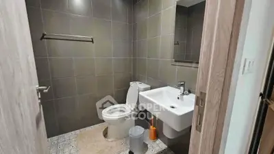 Modern bathroom with sleek fixtures and tiled walls in a contemporary apartment.