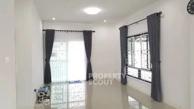 Spacious empty room with large windows and elegant curtains, perfect for customization.