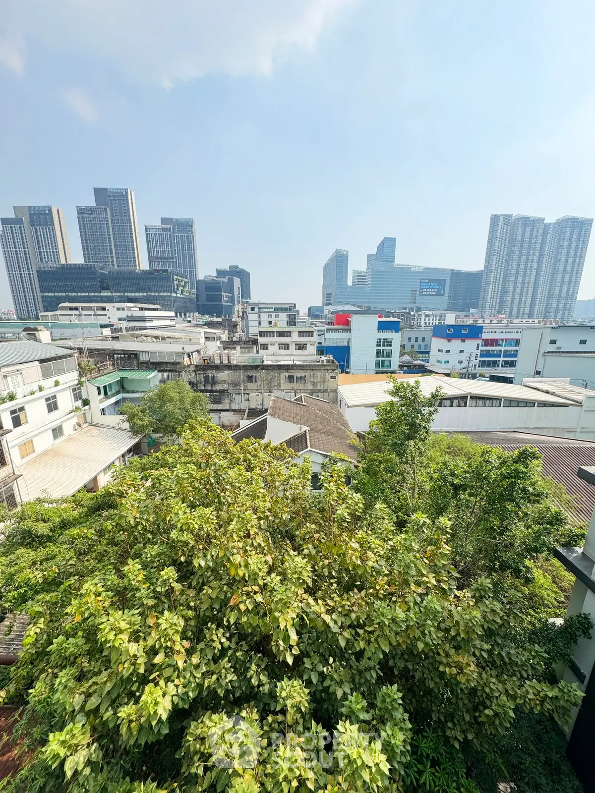 Stunning cityscape view with lush greenery and modern high-rise buildings.
