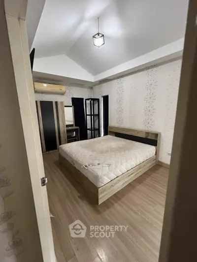 Spacious bedroom with modern decor and wooden flooring