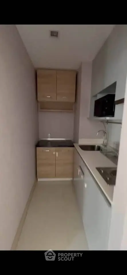 Compact modern kitchen with sleek cabinetry and integrated appliances in a minimalist design.