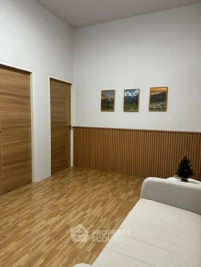 Modern minimalist living room with wooden flooring and wall decor