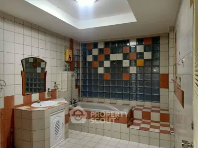 Spacious bathroom with unique tile design and built-in bathtub