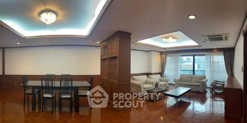 Spacious living room with elegant dining area and cozy seating, featuring wooden flooring and modern lighting.