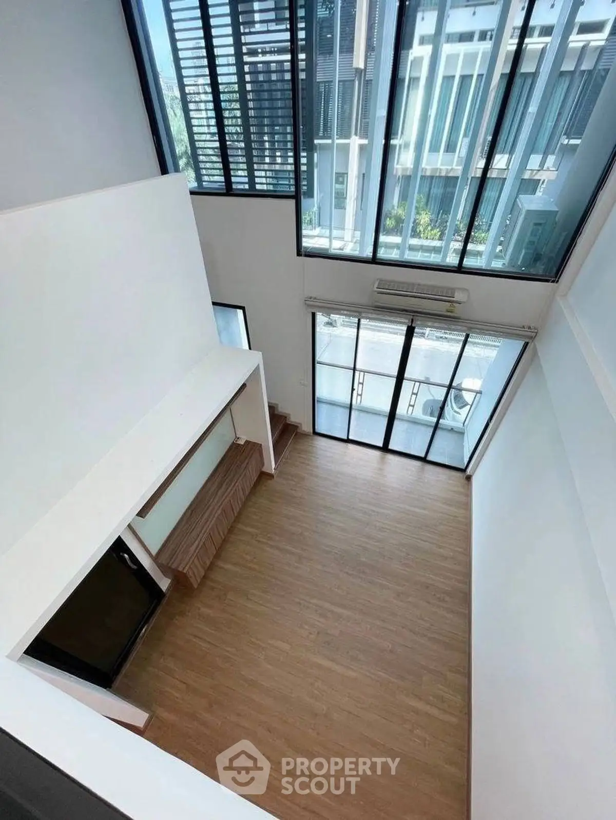 Spacious modern living room with high ceilings and large windows offering ample natural light.