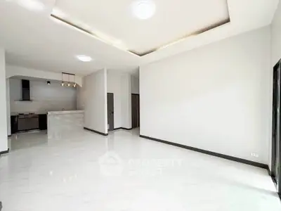 Spacious modern living room with open kitchen and elegant lighting