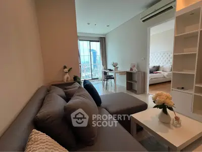 Modern living room with cozy sofa and city view, adjacent to elegant bedroom.