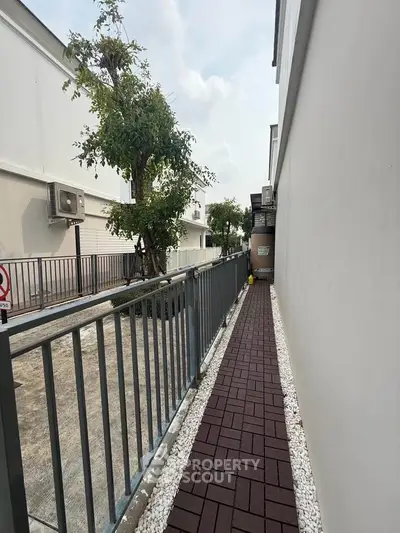 Narrow outdoor walkway with modern design and greenery