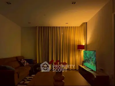 Cozy living room with warm lighting, modern furniture, and a flat-screen TV for ultimate relaxation.