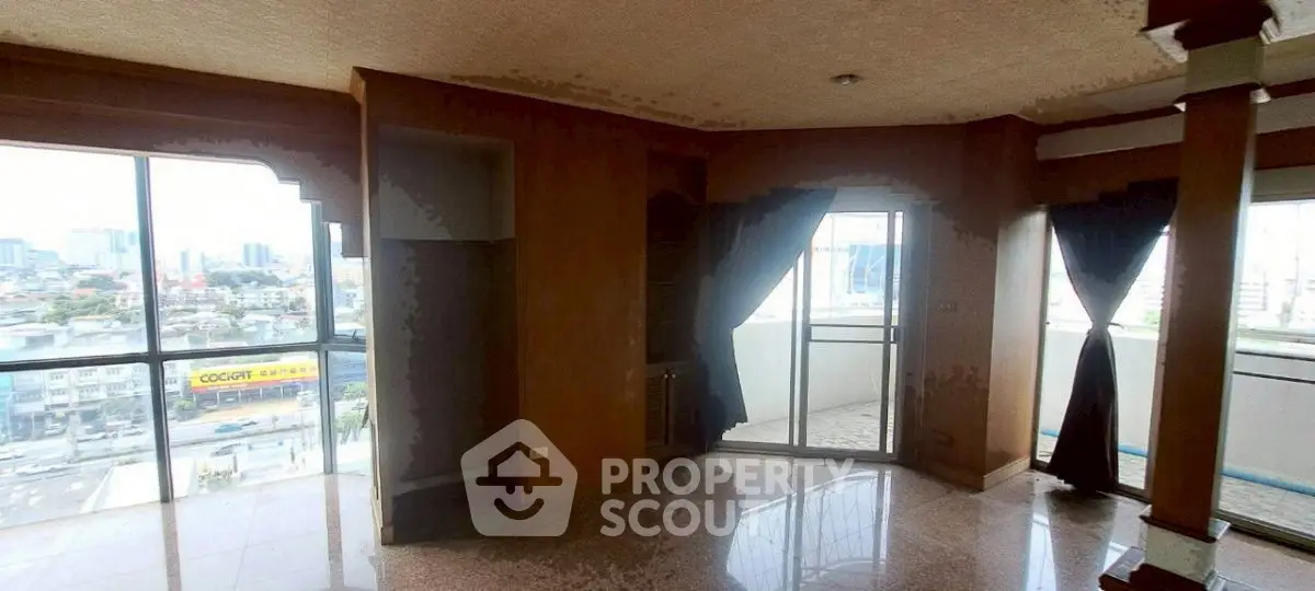 Spacious living room with large windows and city view, featuring a small balcony.