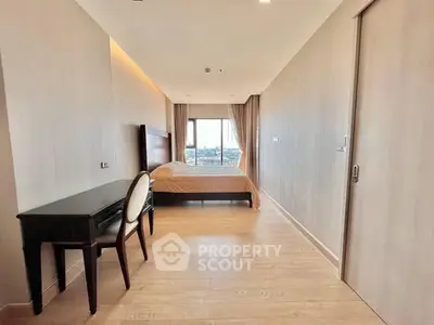 Spacious bedroom with modern decor and large window offering city views.