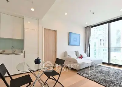 Modern living room with sleek furniture and large windows offering city views.