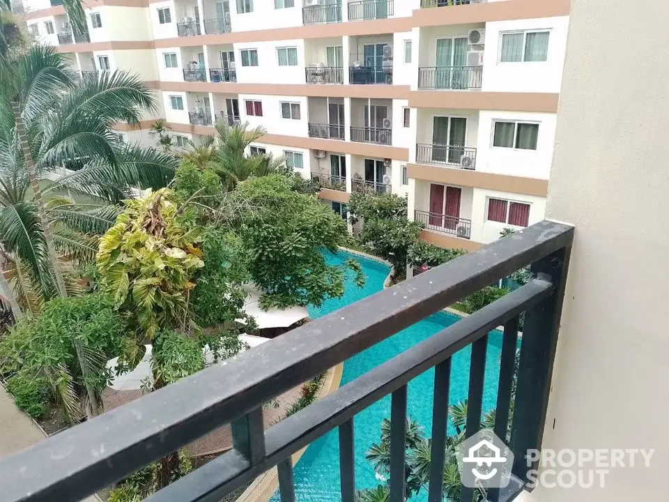 Stunning view of modern apartment complex with lush greenery and inviting swimming pool.