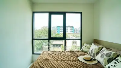 Cozy bedroom with large window offering a serene view of the cityscape.