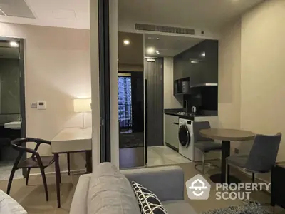 Modern apartment interior with open kitchen and cozy living area, featuring stylish furniture and appliances.