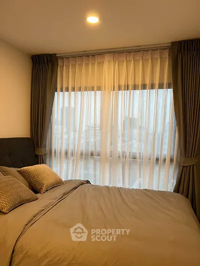 Cozy bedroom with elegant curtains and city view, perfect for relaxation.