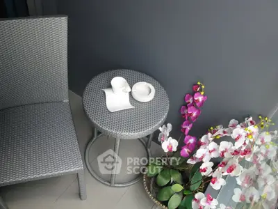 Charming balcony with elegant wicker furniture and vibrant orchids, perfect for relaxation.