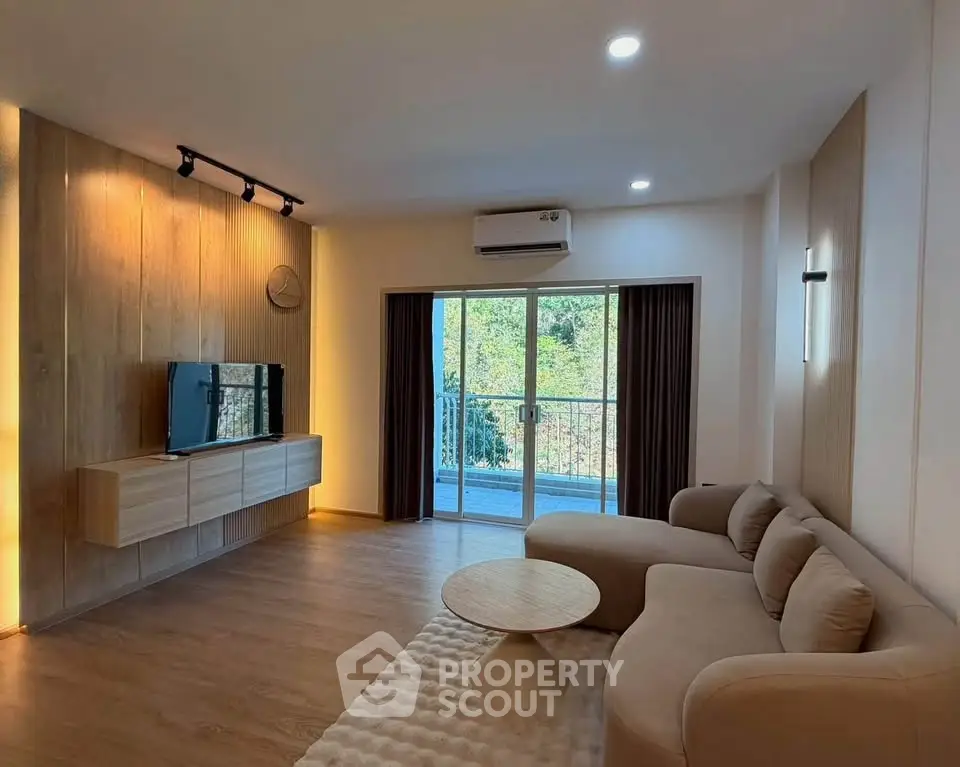 Spacious modern living room with cozy sofa and balcony view