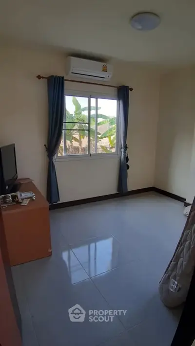 Cozy bedroom with air conditioning and window view, ideal for relaxation.