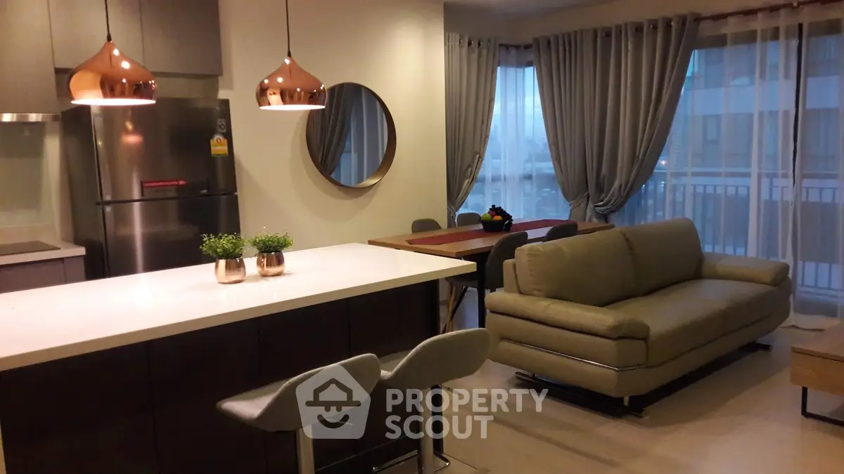 Modern open-layout kitchen and living room with stylish decor and natural light.