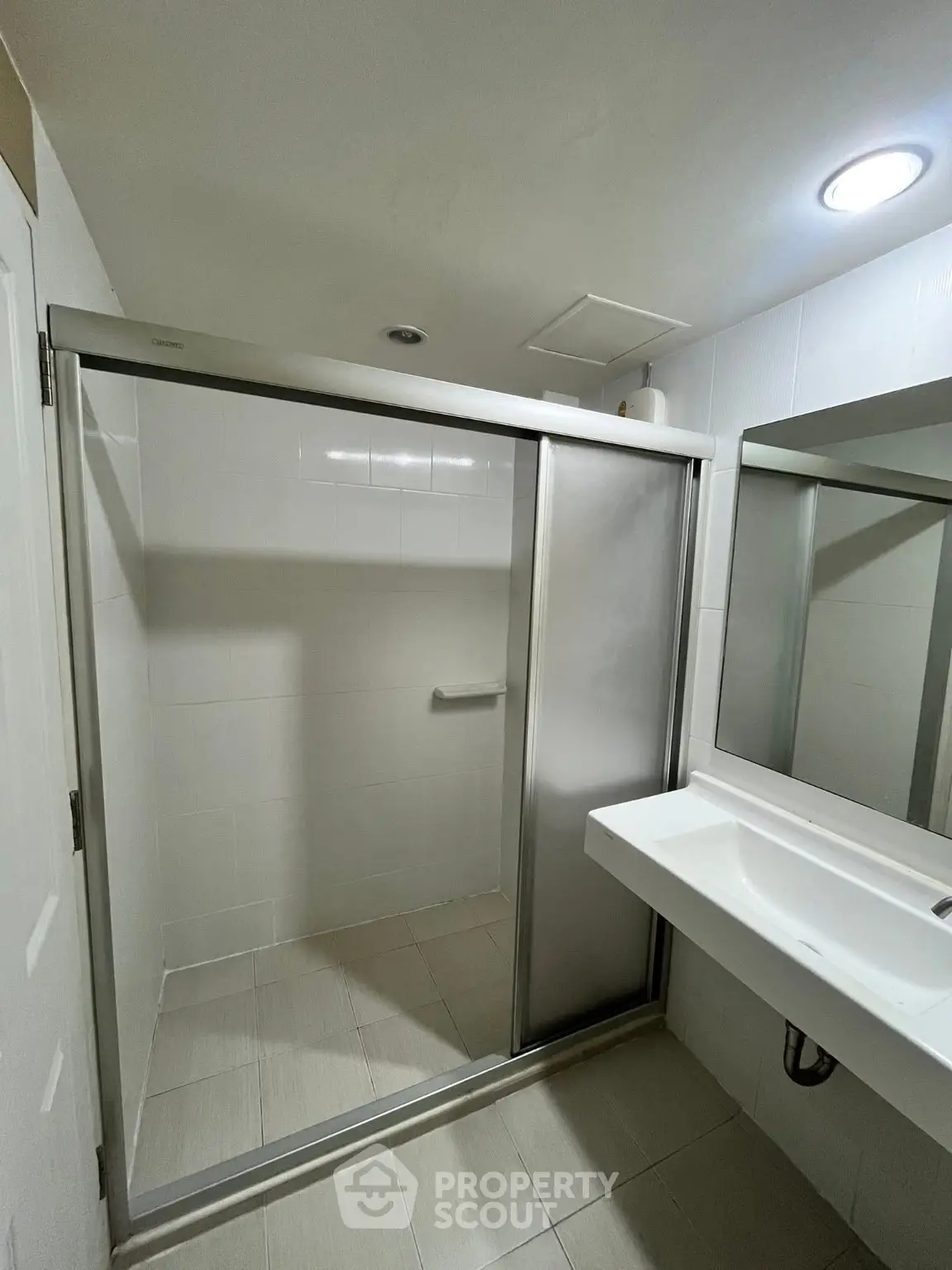 Modern bathroom with sleek shower enclosure and contemporary sink design.