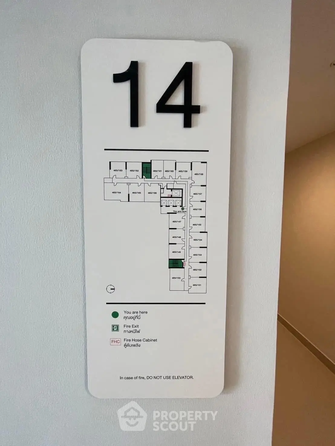 Floor plan sign on wall indicating emergency exits and room layout on the 14th floor.