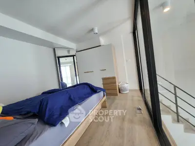 Modern bedroom with glass wall and wooden flooring in stylish apartment