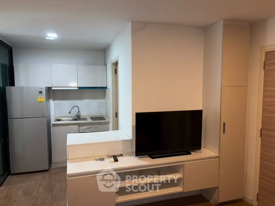 Modern compact kitchen with sleek appliances and integrated living area