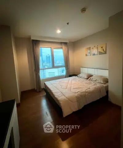 Cozy bedroom with city view, featuring a comfortable bed and elegant decor, perfect for relaxation.