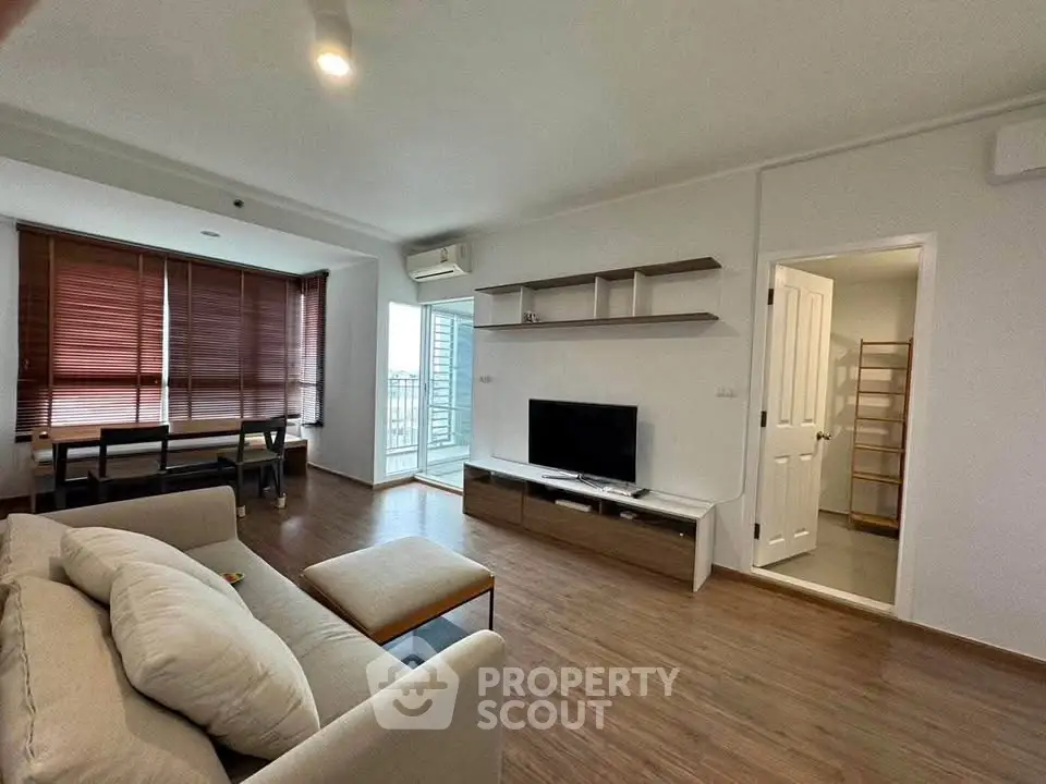 Spacious modern living room with wooden flooring and large windows in a stylish apartment.