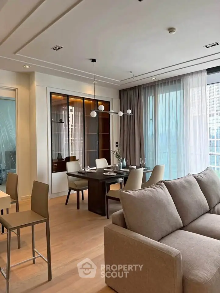 Modern living room with elegant dining area and large windows in a stylish apartment.