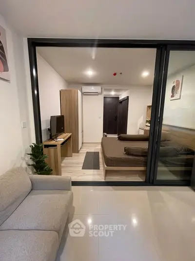 Modern studio apartment with open layout and stylish furnishings, featuring a cozy living area and bedroom.