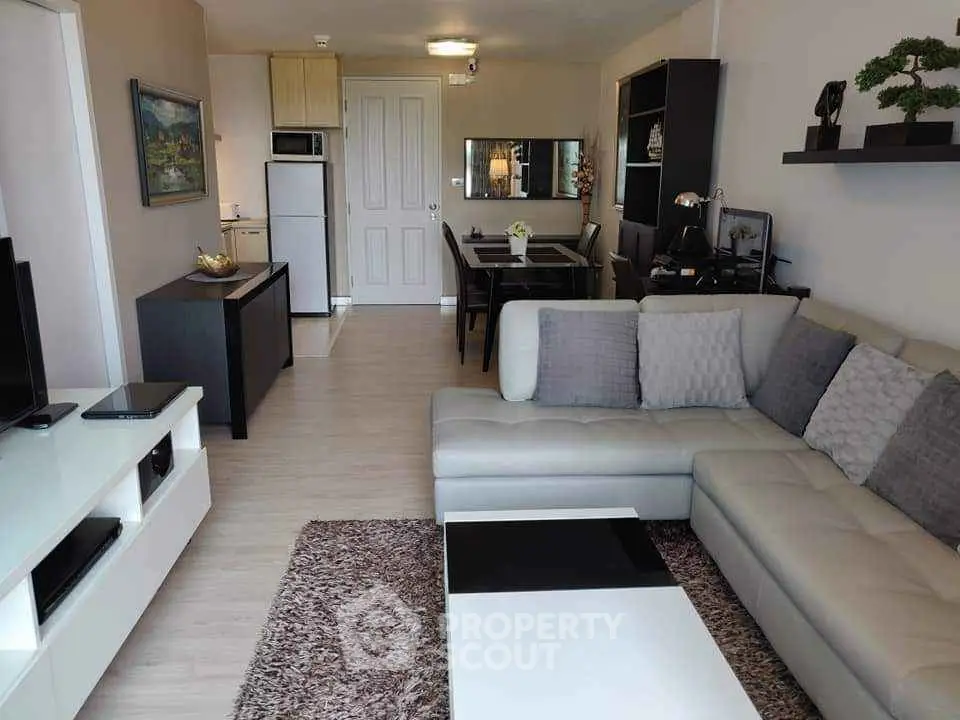 Modern living room with stylish decor and open layout, featuring a cozy sectional sofa and elegant dining area.