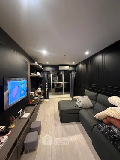 Modern living room with sleek black walls, cozy sectional sofa, and entertainment center in stylish apartment.