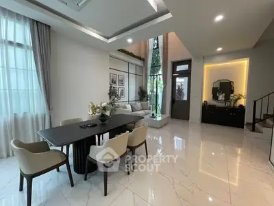 Luxurious modern living room with high ceilings and elegant dining area