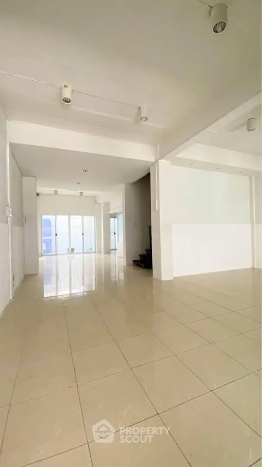 Spacious open-plan living area with large windows and tiled flooring, perfect for modern living.