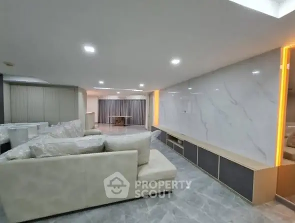 Spacious modern living room with elegant marble accents and plush seating