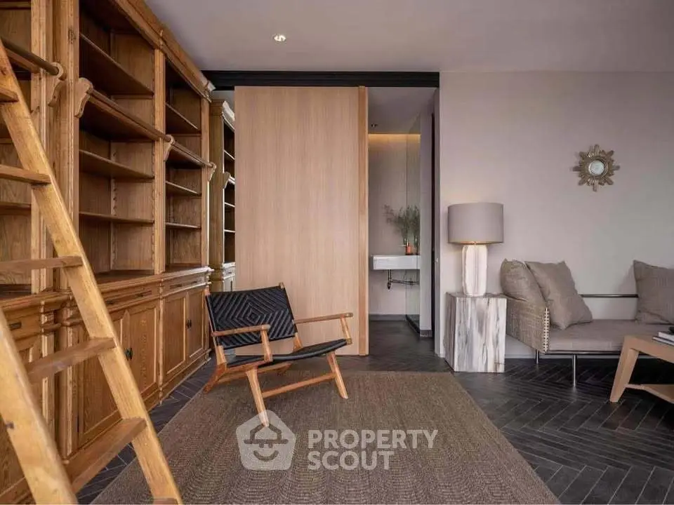 Chic study room with wooden bookshelves and modern seating in a stylish home.